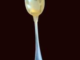 a silver spoon with a gold spoon handle on a black background