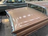 a brown car parked in a parking lot next to other cars