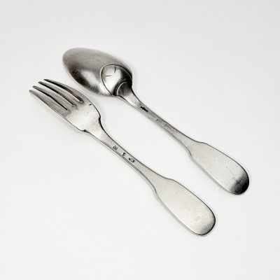 deux cuillères et une fourchette sur une surface blanche