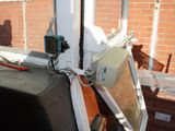 a broken tv sitting on a window sill outside