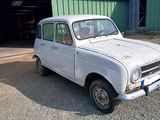 une vieille voiture blanche garée devant un immeuble