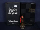 un flacon de parfum et un coffret de parfum posés sur une surface bleue