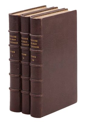 trois livres marron sont empilés les uns sur les autres sur une surface blanche