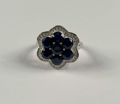 une bague en or blanc sertie d'un saphir bleu et de diamants