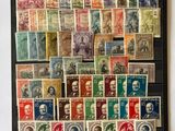 a black frame holds a collection of old postages and stamps
