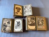 several old photographs of men in military uniforms are stacked on a table