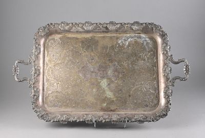 an antique silver tray with handles on a stand on a gray background