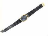 an image of a black watch with a gold buckle on it