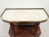 an old wooden table with a marble top on a hard wood floor