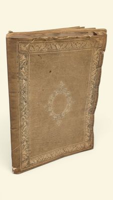 an old book is sitting on a white surface with a white background