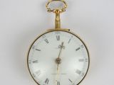 a gold pocket watch with roman numerals on the face