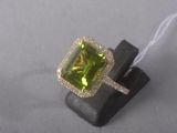 an image of a ring with a green stone surrounded by diamonds