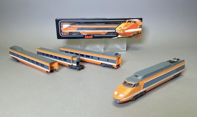 trois trains miniatures assis l'un à côté de l'autre sur une table