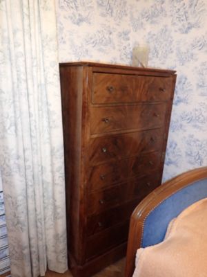 un lit et une commode dans une chambre au papier peint bleu et blanc