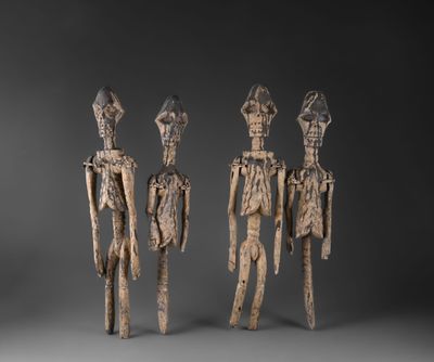 un ensemble de trois figurines en bois sculptées, placées les unes à côté des autres