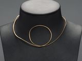 a black mannequin with a gold necklace on it