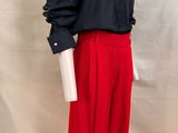 un t-shirt noir et rouge et un pantalon rouge posés sur un socle de mannequin