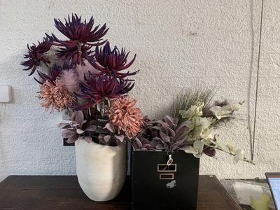 deux vases contenant des fleurs, posés sur une table