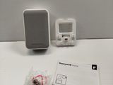 a small white speaker sitting on a table next to a card