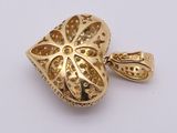 a close up of a gold plated pendant on a white surface