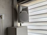 a white box with a speaker on top of it next to a window