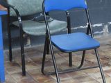 a blue chair sitting next to a blue table on a tiled floor