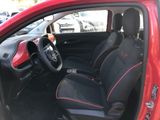 the interior of a red car with black seats and a steering wheel