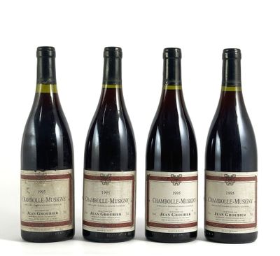 trois bouteilles de vin rouge sont alignées sur une surface blanche