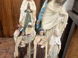 a statue of a woman and a man and a group of figurines on a table