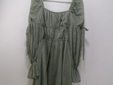 a green top hanging on a hanger in a room