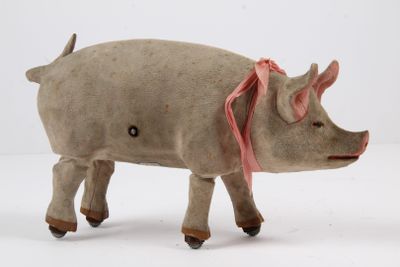 un petit cochon en peluche avec un ruban rose sur la tête