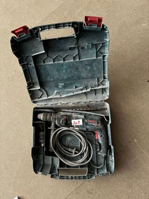 une boîte à outils contenant un cordon, posée par terre