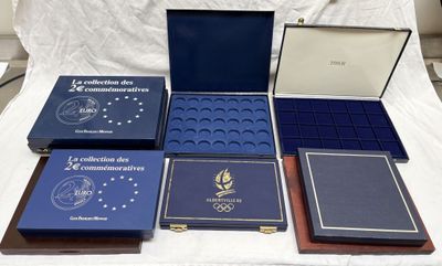 six cartons contenant des livres commémoratifs sont posés sur un lit recouvert d'un drap blanc