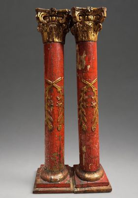 paire de colonnes peintes en rouge et or, ornées de décorations dorées
