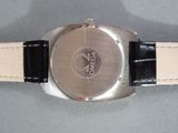 a silver watch with a black band on a table