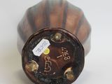 a brown and black vase with a tag on it
