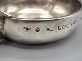 a silver bowl with a spoon in it on a table