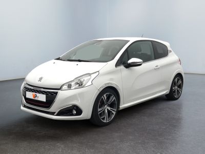 La voiture blanche est garée dans une pièce au sol noir.