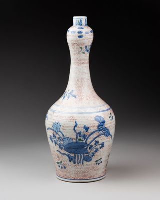 blue and white vase with flowers and birds on it on a gray surface