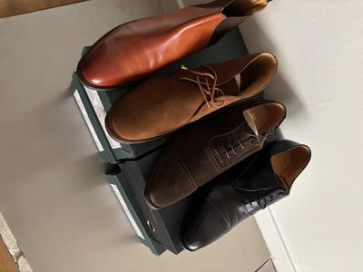 trois paires de chaussures posées sur une valise