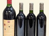 four bottles of wine are lined up in a row on a table