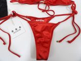 sexy red bikini set with matching bra and thongs on a white table