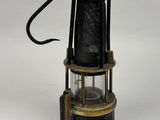 a black and gold lantern with a wire attached to it