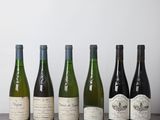 six bouteilles de vin alignées sur une table en bois
