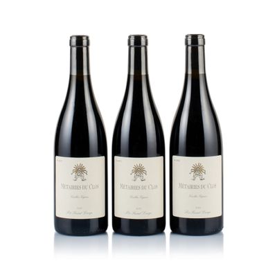 three bottles of red wine sitting next to each other on a white surface