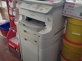 a printer that is sitting on the floor next to a trash can