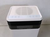 a white and black air purifier sitting on top of a counter