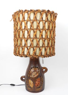 une lampe surmontée d'un abat-jour tissé