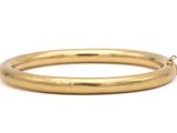 a close up of a gold bracelet on a white background