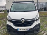 l'avant d'une camionnette blanche garée devant un immeuble